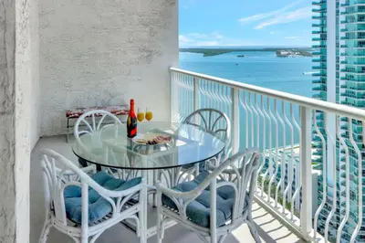 a table and chairs on a balcony with a view of the ocean at Brickell Bay Condo with Views plus Parking Sleeps 6 in Miami
