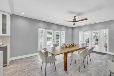 a dining room with a wooden table and white chairs at Miami Sombra - Prime Location-Parkfront- Den-Gazebo in Miami
