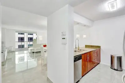 a white kitchen with a sink and a counter at Stylish Brickell Condo with Balcony and Parking in Miami