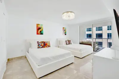 a white living room with two white couches at Stylish Brickell Condo with Balcony and Parking in Miami
