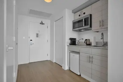 a kitchen with white cabinets and a microwave at Modern Comfort Steps from the Ocean Breeze in Miami