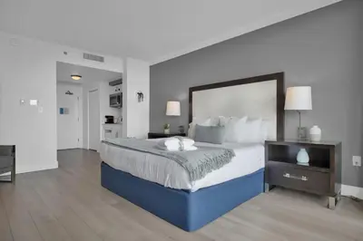 a large bedroom with a large bed and a table at Modern Comfort Steps from the Ocean Breeze in Miami
