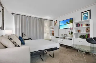 a bedroom with a bed and a couch and a tv at Bayshore Charm-Free Parking in Miami