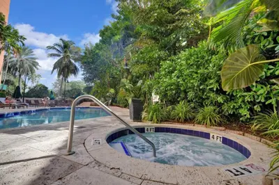 a swimming pool with a hot tub in a resort at Sunny Getaway, Pool and Parking in Miami