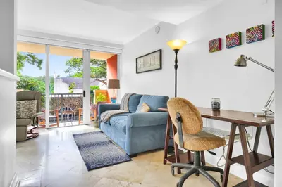 a living room with a blue couch and a table at Sunny Getaway, Pool and Parking in Miami