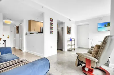 a living room with a blue couch and a chair at Sunny Getaway, Pool and Parking in Miami