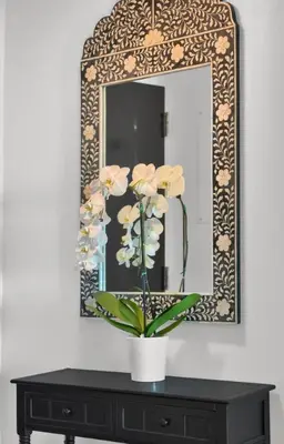 a vase with flowers on a table in front of a mirror at Coastal Elegance and Luxury by the Water in Miami