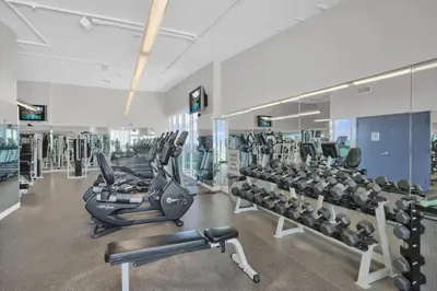 a gym with rows of treadmills and machines at Grove Escape-Ocean Glimpse in Miami