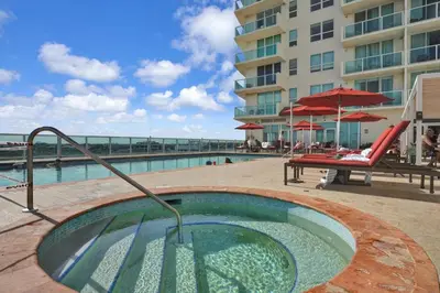 a pool with a hot tub next to a building at The Harmony - Ocean and Relaxation in Miami