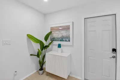 a white room with a white door and a plant at Victoria Park's Secret Estate in Fort Lauderdale