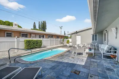 a backyard with a swimming pool and a house at Victoria Park's Secret Estate in Fort Lauderdale