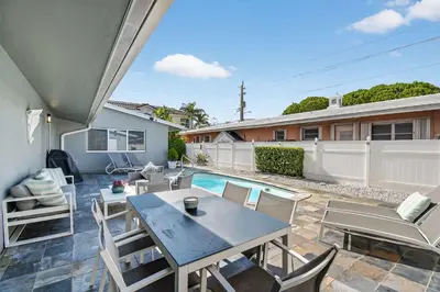 a patio with a table and chairs and a pool at Victoria Park's Secret Estate in Fort Lauderdale