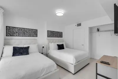a bedroom with two white beds and a desk at Stunning 2B2B Ocean and City Views with Free Parking in Miami