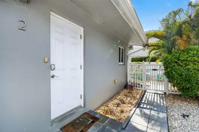 a white door to a house with a fence at Victoria Park's Secret #2 - 6ppl in Fort Lauderdale