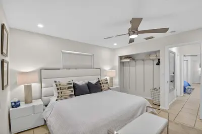 a white bedroom with a bed and a ceiling fan at Victoria Park's Secret #1 - 6ppl in Fort Lauderdale