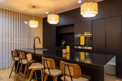 a kitchen with a large black counter and chairs at 3BR Vibrant Havana Villa in Miami, Pool, Grill, Backyard in Miami