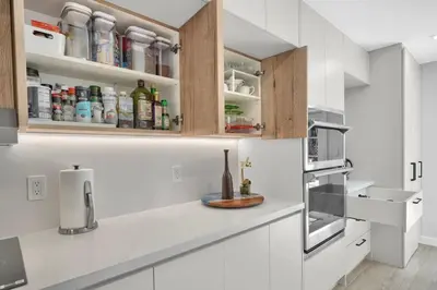 a kitchen with white cabinets and white appliances at Home Away From Home in Coconut Grove in Miami