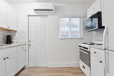 a kitchen with white cabinets and a white door at Luxury Miami Studio Close to Wynwood & Downtown in Miami