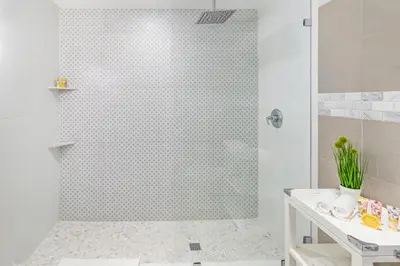 a bathroom with a shower with a glass door at Henrosa Hotel in Miami Beach