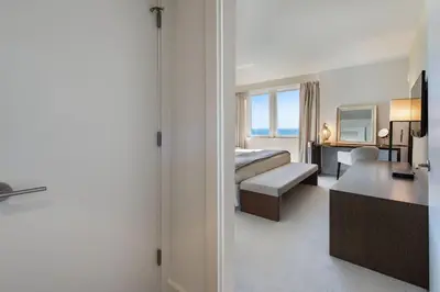 a hotel room with a bed and a desk at Lumina Residences 2BR Skyline Escape in Miami Beach