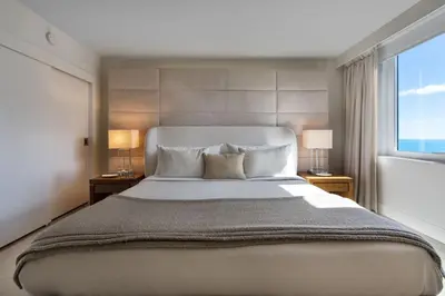a bedroom with a large bed and a window at Lumina Residences 2BR Skyline Escape in Miami Beach