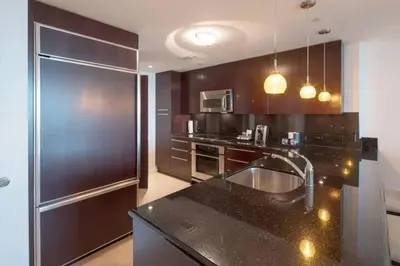 a kitchen with a sink and a stainless steel refrigerator at Fontainebleau Sorrento Jr suite in Miami Beach