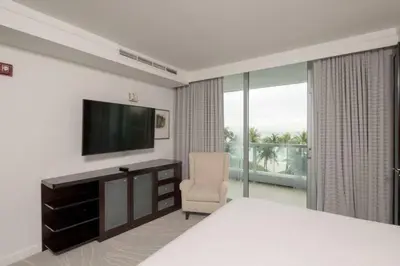 a bedroom with a bed and a television and a chair at Fontainebleau Sorrento Jr suite in Miami Beach