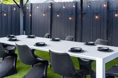 a white table with black chairs and a fence at Parisian Vibe in Design District Miami with Private Pool BBQ Spacious Backyard in Miami