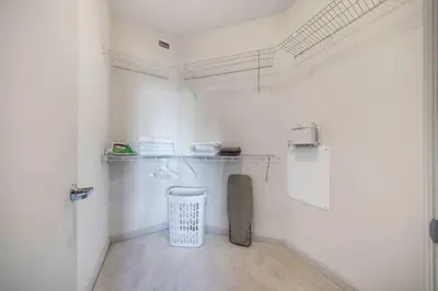a bathroom with white walls and a trash can at Aqua Luxe in DTWN 3 Min From Las Olas in Fort Lauderdale