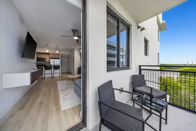 a room with a balcony with a table and chairs at Isla Blue in DTWN 3 Min From Las Olas in Fort Lauderdale
