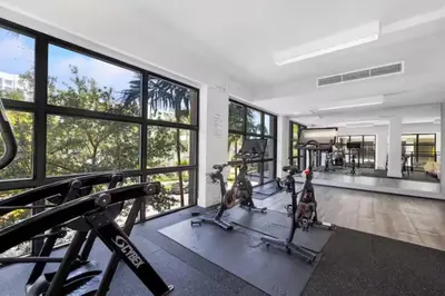 an empty gym with cardio machines and windows at Isla Blue in DTWN 3 Min From Las Olas in Fort Lauderdale