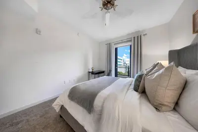 a white bedroom with a large bed and a window at Isla Blue in DTWN 3 Min From Las Olas in Fort Lauderdale