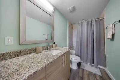 a bathroom with a sink and a toilet and a mirror at Casa Palmera in DTWN 3 Min From Las Olas in Fort Lauderdale