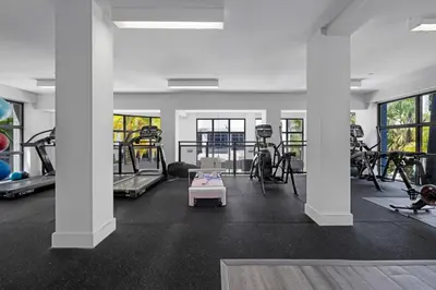 a gym with several treadmills and exercise bikes at Casa Palmera in DTWN 3 Min From Las Olas in Fort Lauderdale