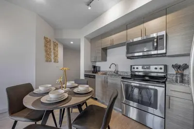 a kitchen with a table and chairs and a microwave at Prestige Living in DTWN 3 Min From Las Olas in Fort Lauderdale
