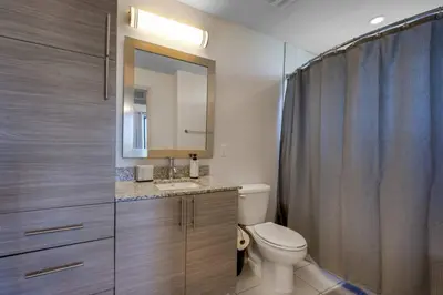 a bathroom with a toilet and a sink and a mirror at Prestige Living in DTWN 3 Min From Las Olas in Fort Lauderdale
