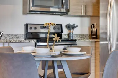a kitchen with a table with chairs and a microwave at Prestige Living in DTWN 3 Min From Las Olas in Fort Lauderdale