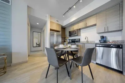 a kitchen with a table and chairs in a kitchen at Modern Palmera in DTWN 3 Min From Las Olas in Fort Lauderdale