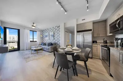 a kitchen and living room with a table and chairs at Serene Bleu in DTWN 3 Min From Las Olas in Fort Lauderdale