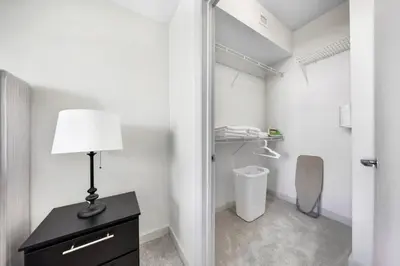 a room with a lamp on a dresser and a closet at The Serenity in DTWN 3 Min From Las Olas in Fort Lauderdale
