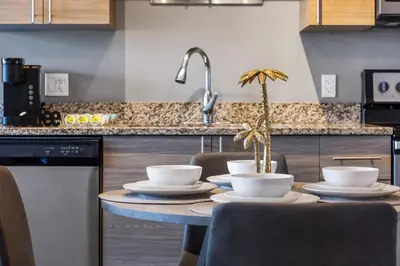 a kitchen with a table with chairs and a sink at Palm Paradise in DTWN 3 Min From Las Olas in Fort Lauderdale