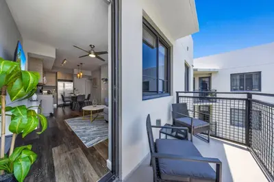 a balcony with chairs and a table and a dining room at Palm Paradise in DTWN 3 Min From Las Olas in Fort Lauderdale