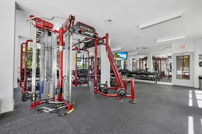 a gym with red equipment and tread machines at Palm Paradise in DTWN 3 Min From Las Olas in Fort Lauderdale