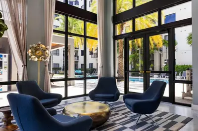 a lobby with chairs and a table and large windows at Aqua Vista in DTWN 3 Min From Las Olas in Fort Lauderdale