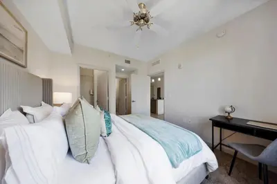a bedroom with a white bed with a ceiling fan at Coral Haven in DTWN 3 Min From Las Olas in Fort Lauderdale