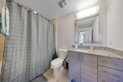 a bathroom with a toilet and a sink and a mirror at Coral Haven in DTWN 3 Min From Las Olas in Fort Lauderdale