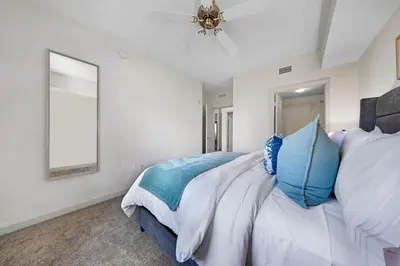 a bedroom with a large bed with blue and white pillows at Coral Haven in DTWN 3 Min From Las Olas in Fort Lauderdale