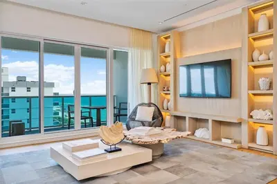 a living room with a large window and a tv at Villa Royale Residences in Miami Beach