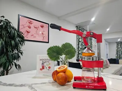 a red machine sitting on a table with oranges at The Ruby - Hot Tub - King beds - Close to LMC in Fort Lauderdale