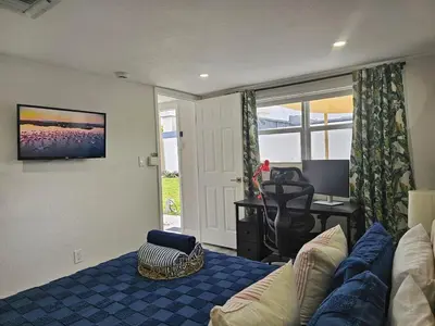 a living room with a couch and a desk at The Ruby - Hot Tub - King beds - Close to LMC in Fort Lauderdale